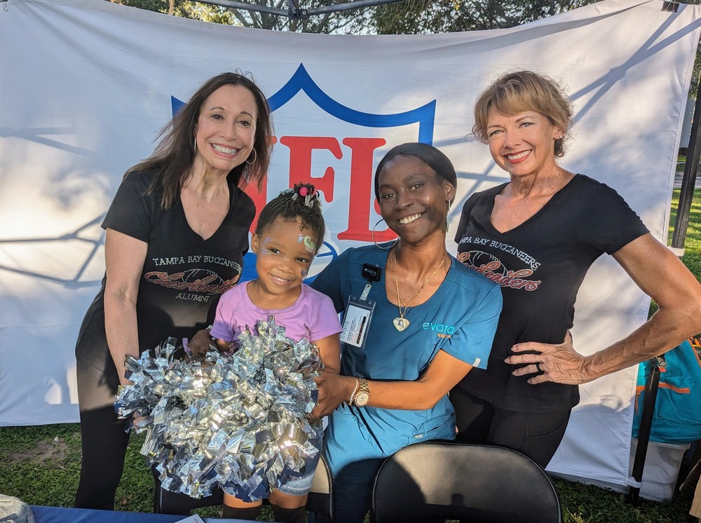 Image of happy family and Alumni NFL Cheerleaders at Jordan Park Back to School event.