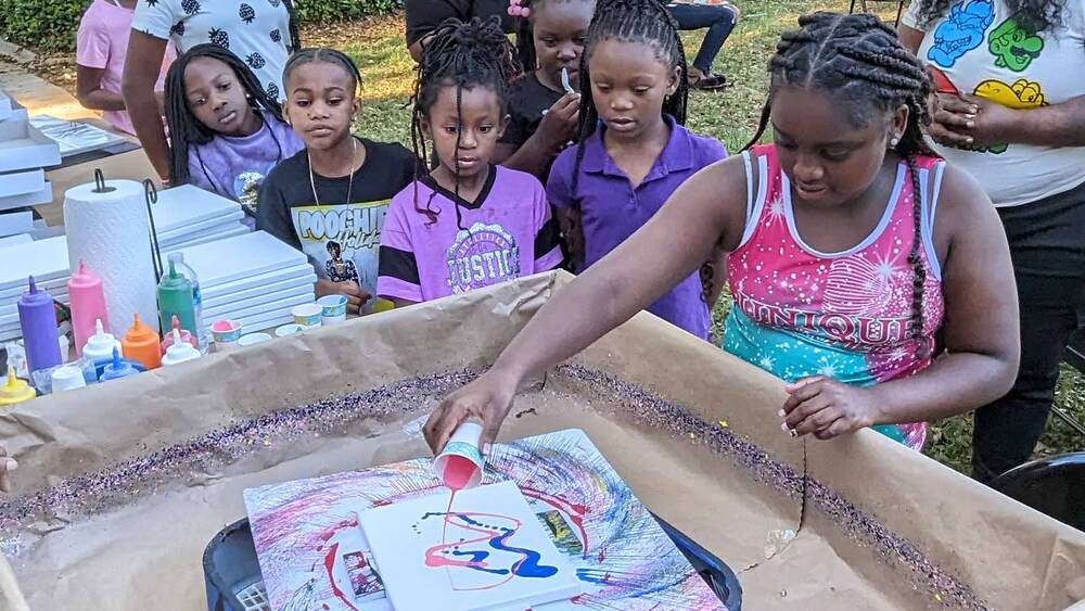 Kids participating in spin art workshop at Disston Place Apartments.