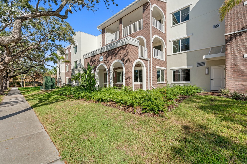 Trees and community balconies of The Legacy at Jordan Park senior midrise building.