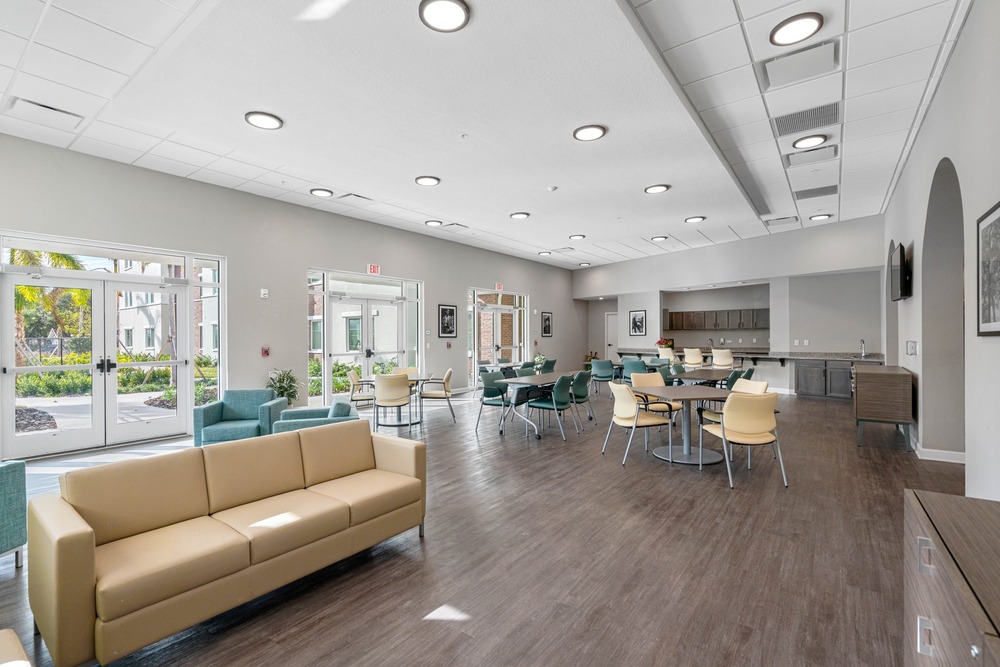 Downstairs community room with tan couch inside The Legacy at Jordan Park senior midrise building.