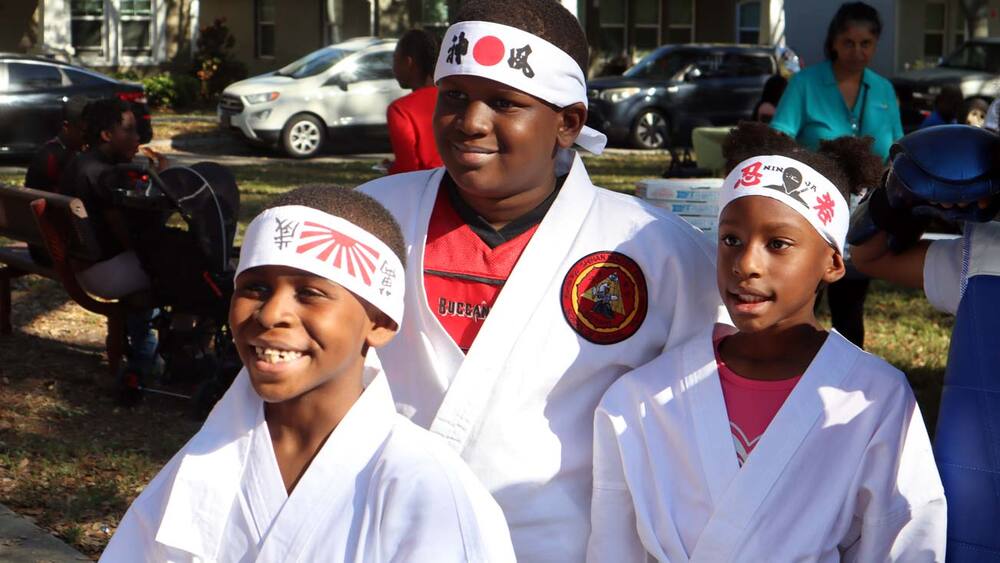Three young martial arts students at the Spring Family Picnic in Jordan Park.