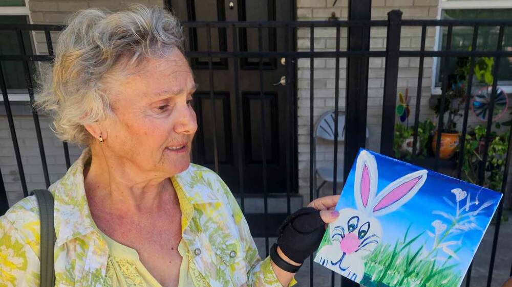 Woman holding a painting of a bunny.