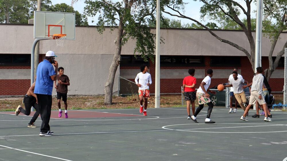 Group of youth playing basketball at Wildwood Park.