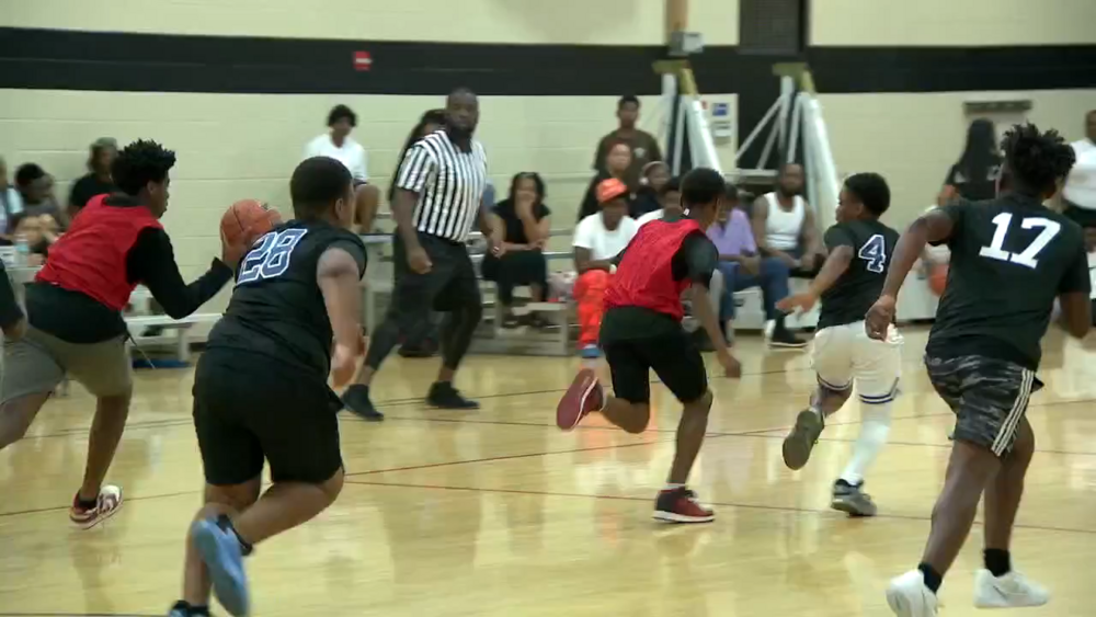 Group of kids running on basketball court.