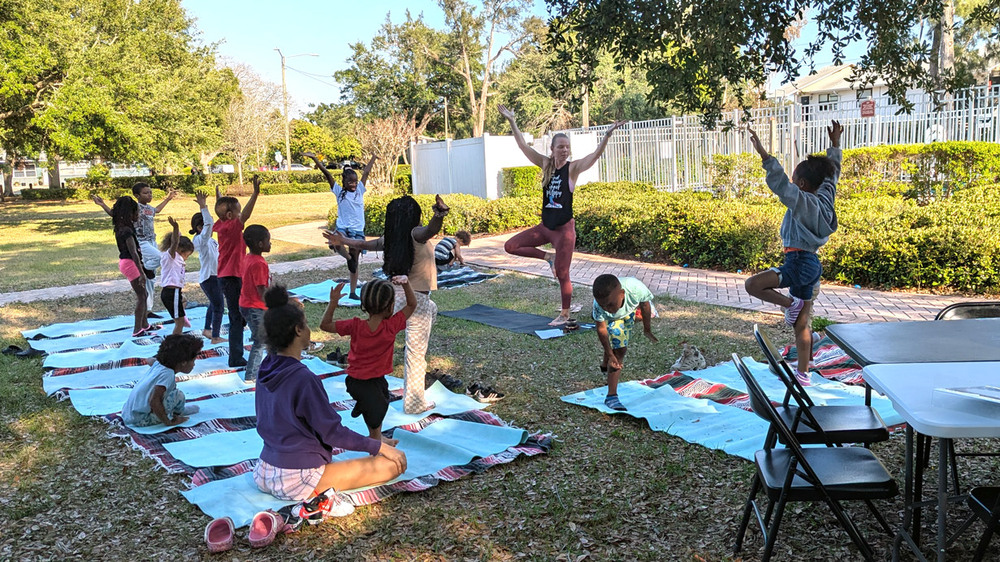 Families engaged in yoga session at Disston Place Apartments.