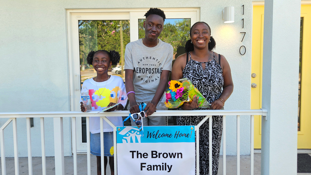 Shanieh Brown and her two children in front of their new home.
