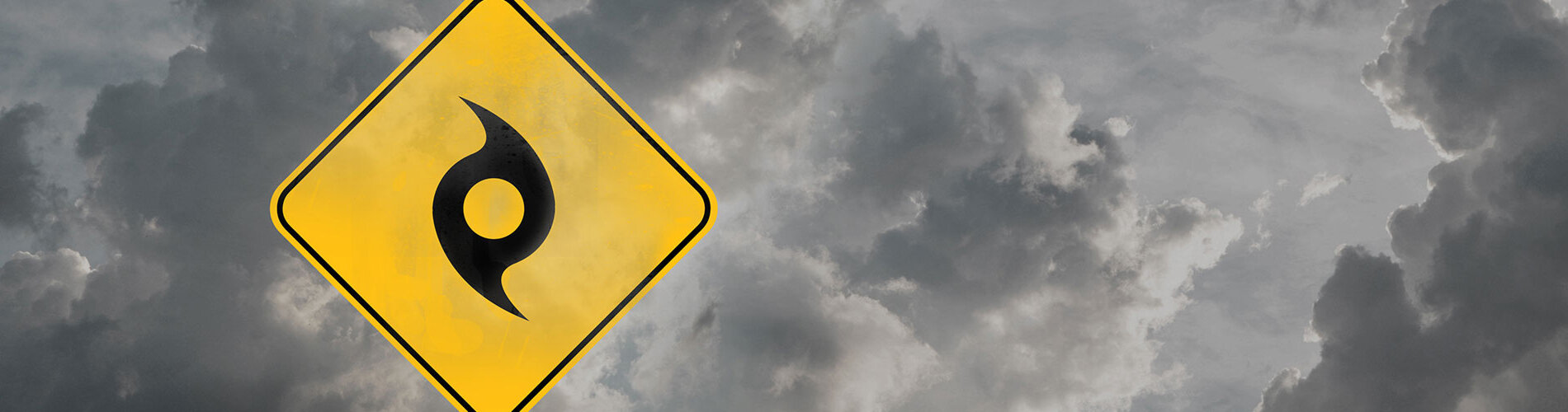 Gray storm clouds with a hurricane symbol on a yellow sign.