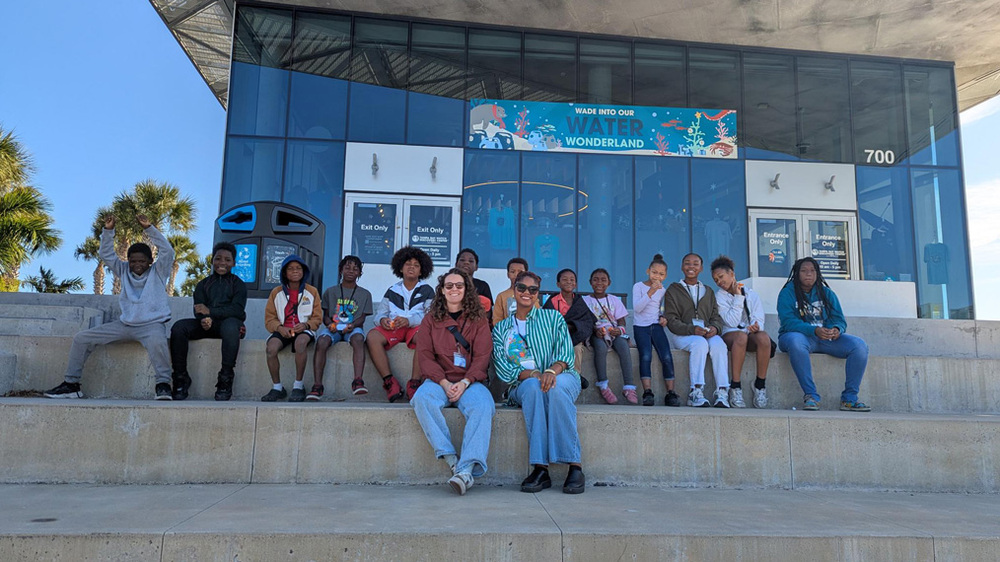 Jade Timmons (SPHA's Youth & STEM Program Coordinator), Amiya Sloan (SPHA's STEM Education & Innovation Specialist), and SPHA youth at the Tampa Bay Watch Discovery Center.