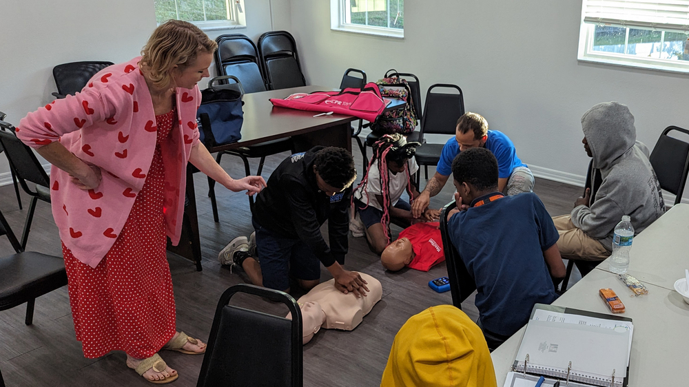 Courtney Burt, Community Impact Vice President, Tampa Bay, American Heart Association teaches SPHA youth how to perform CPR.