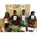 Four kids holding drawings of broccoli.