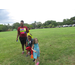Parent and kids on large park lawn.