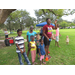 Several children and adults enjoying a day in the park.