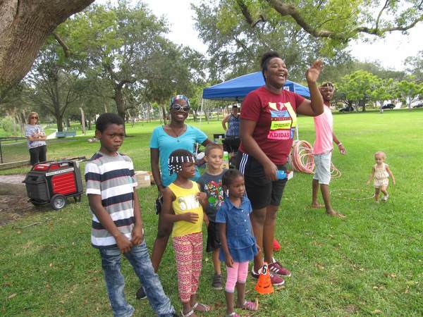 Several Children and adults enjoying a day in the park