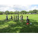 Man with microphone lining kids up on grass.