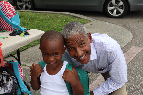 SPHA President and CEO Michael Lundy next to a young boy wearing a backpack.