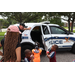 Policeman giving a tour of his police car to children.