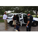 Policeman giving a tour of his police car to children with SPHA President and CEO Michael Lundy standing near the car.