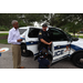 Policeman giving a tour of his police car to children with SPHA President and CEO Michael Lundy holding the car door.