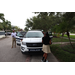Policeman giving a tour of his police car to children with SPHA President and CEO Michael Lundy standing near the passenger door.