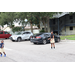 Two children playing with a ball in a parking lot.