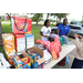 Backpacks and snacks on table with people standing beside the table.