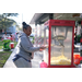 Woman at popcorn machine at Very Merry Holiday Party at Jordan Park.