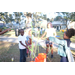 Children playing with bubbles and orange bucket at Very Merry Holiday Party at Jordan Park 2022.