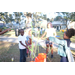 Children playing with bubbles and orange bucket at Very Merry Holiday Party at Jordan Park.