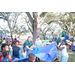Children playing in grass area with trees behind them at Very Merry Holiday Party at Jordan Park.
