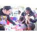 Person wearing purple gloves and families at Very Merry Holiday Party at Jordan Park.
