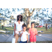 Woman wearing a hat and two children smiling at Very Merry Holiday Party at Jordan Park.