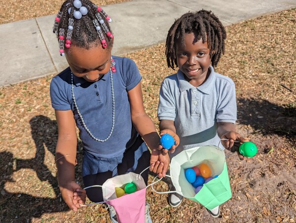 Two children with plastic eggs at Jordan Park Easter Egg Hunt.