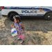 Child near police car searching for eggs at Jordan Park Easter Egg Hunt.