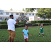 Children playing in the green grass on a sunny day at Disston Place Apartments Back to School Event 2023.