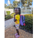 Girl in yellow shirt with purple backpack at Disston Place Apartments Back to School Event 2023.