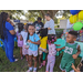 Young girl smiling and holding a water bottle with a group of children at Disston Place Apartments Back to School Event 2023.