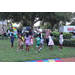 United Way Suncoast team and children dancing in green grass at Disston Place Apartments Back to School Event 2023.