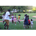 United Way Suncoast team and children dancing in green grass at Disston Place Apartments Back to School Event 2023.