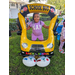 Child and balloon yellow school bus in green grass at Disston Place Apartments Back to School Event 2023.