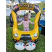 Child standing behind a balloon yellow school bus at Disston Place Apartments Back to School Event 2023.