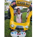 Young girl smiling and standing behind balloon school bus at Disston Place Apartments Back to School Event 2023.