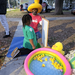 United Way Suncoast member wearing yellow duck hat and playing games with children at Very Merry Holiday Party 2023.