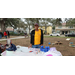 Jordan Park Projects Nostalgic Association person in yellow shirt standing by table at Very Merry Holiday Party in Jordan Park.