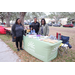 People smiling by LEADS table at Very Merry Holiday Party in Jordan Park.