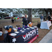 people standing by HOPE Villages of America table at Very Merry Holiday Party in Jordan Park.