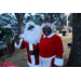Santa Claus waving and Mrs. Claus smiling at Very Merry Holiday Party in Jordan Park.
