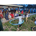Children in grass playing with hula hoops at Very Merry Holiday Party.