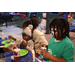 Child eating a snow cone at holiday craft table at Very Merry Holiday Party in Jordan Park.