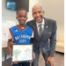 SPHA Kid's Art Contest winner for the month of October 2024 holding their artwork, standing next to SPHA President/CEO Michael Lundy at The Legacy at Jordan Park.