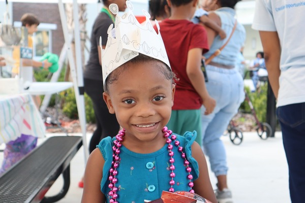 Child outside wearing paper crown outside at SPHA Winter Wonderland event.